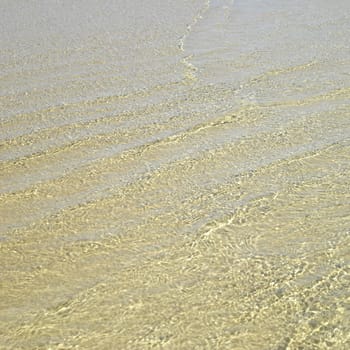 Clear ocean water on gold sand