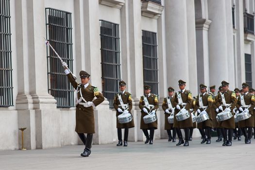 Female members of the Carabineros marching with a ceremonial flag as part of the changing of the guard ceremony at La Moneda in Santiago, Chile