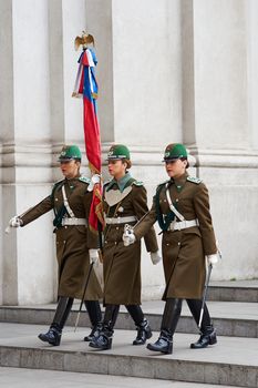 Female members of the Carabineros marching with a ceremonial flag as part of the changing of the guard ceremony at La Moneda in Santiago, Chile