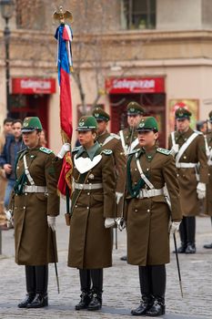 Female members of the Carabineros marching with a ceremonial flag as part of the changing of the guard ceremony at La Moneda in Santiago, Chile