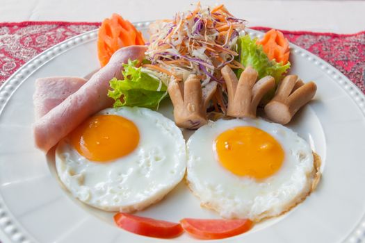 English breakfast with fried eggs, bacon, sausages, beans, toasts and fresh salad