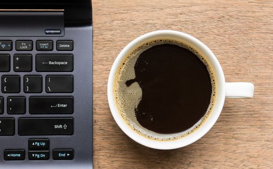 Top view of coffee cup , laptop on wooden table