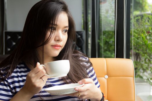 Beautiful woman drinking coffee at cafe