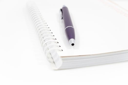 Spiral notebook with pen isolated on white background, stock photo