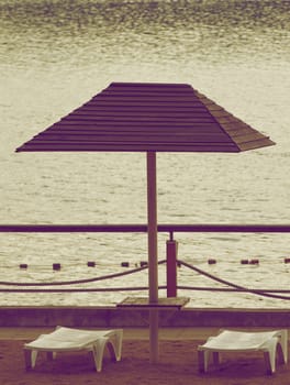 Beach Chairs and Parasol in Cloudy Day Outdoors. Retro Styled