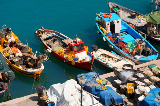 Small fishing boats, red, yellow, blue and white with fishing equipment docked in port - Lerici, La Spezia, Liguria, Italy