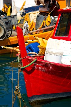 Red and yellow small fishing boats with fishing equipment docked in port - Lerici, La Spezia, Liguria, Italy
