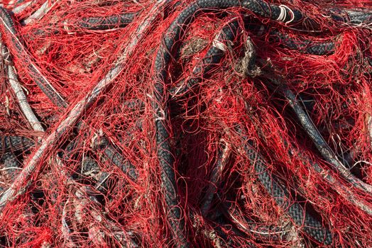 Close up of red fishing net with white and black ropes