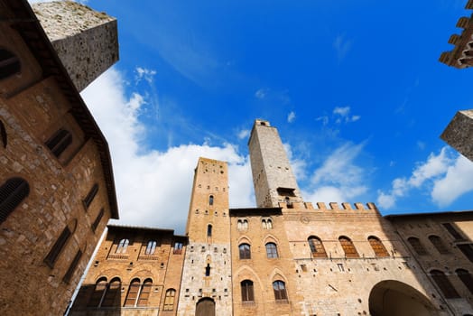 Buildings and towers in Piazza del Duomo, San Gimignano medieval town (UNESCO heritage), Siena, Tuscany, Italy