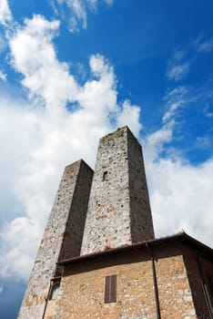 Two towers in Piazza delle Erbe, San Gimignano medieval town (UNESCO heritage), Siena, Tuscany, Italy