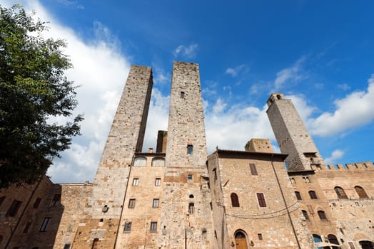 Towers and houses in Piazza delle Erbe and Piazza del Duomo, San Gimignano medieval town (UNESCO heritage), Siena, Tuscany, Italy