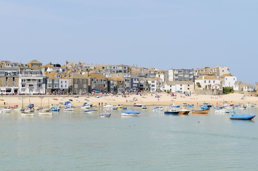 Cornish town by the sea with harbour and fishing boats in summer time