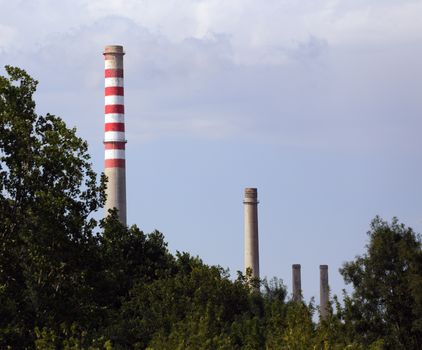 picture of a few industrial chimney with forest foreground