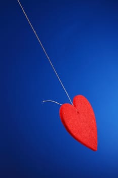 red shape heart  tied twine on blue background