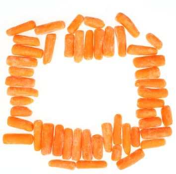 frame of frozen baby carrots over white