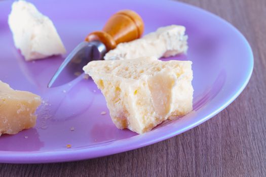 Cheese of different kinds over a purple plate