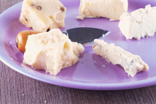 Cheese of different kinds over a purple plate