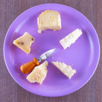 Cheese of different kinds over a purple plate