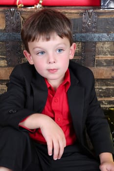 Young boy with a serious expression waiting to open gifts