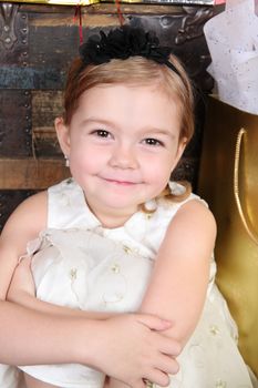 Young christmas girl sitting against a wooden trunk