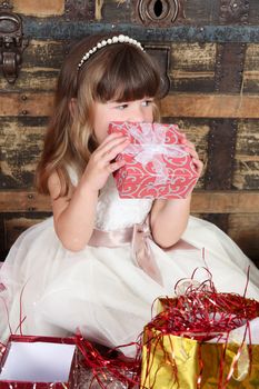 Little girl wearing a christmas dress looking at gifts