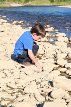 Younb boy playing outside on pebble beach