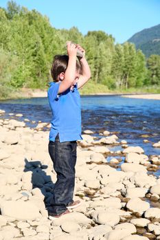 Younb boy playing outside on pebble beach