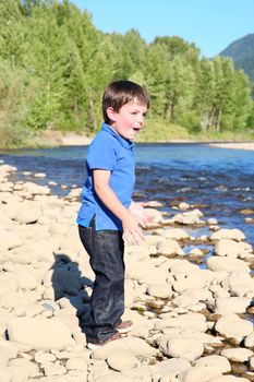 Younb boy playing outside on pebble beach