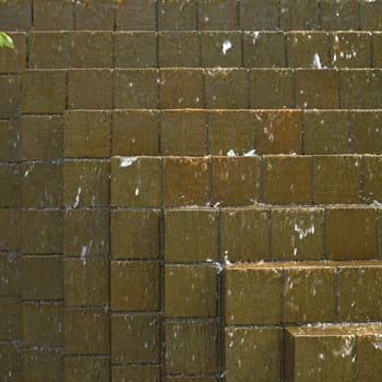 Water falling down on brown bricks