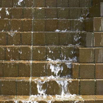 Water falling down on brown bricks