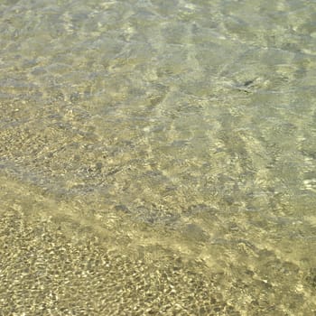 Clear ocean water on gold sand