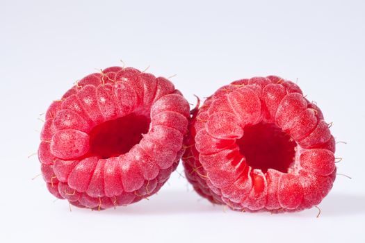 two red rasberries isolated on white background