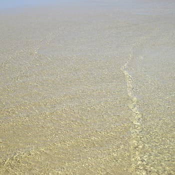 Clear ocean water on gold sand