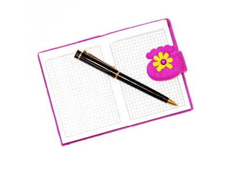 Open notebook in a purple cover with a black ballpoint pen on a white background