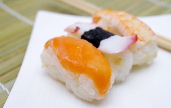 Sushi nigiri in with dish with bamboo sticks 