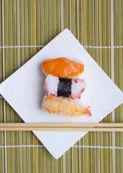 Sushi nigiri in with dish with bamboo sticks