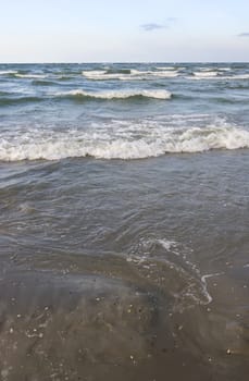 Sea waves splashing on a sandy beach.