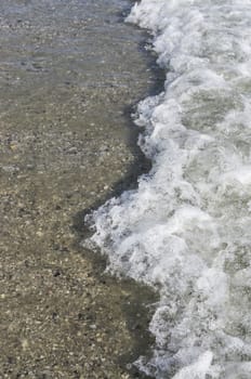 Foam wave splashing on the beach in summer