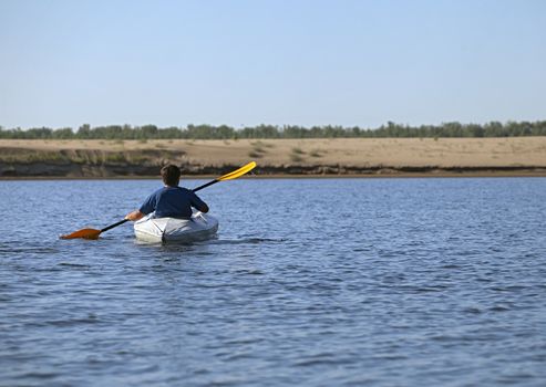 Back of a man rowing in the canoe