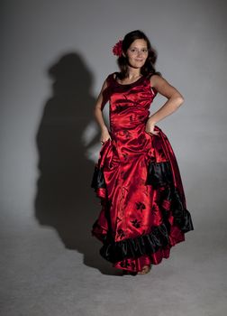 Young woman dancing flamenco, studio shot, gray background