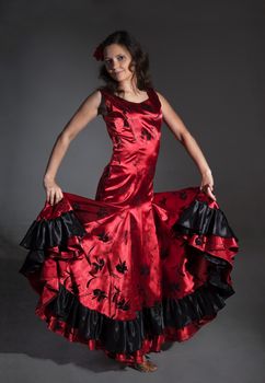 Young woman dancing flamenco, studio shot, gray background