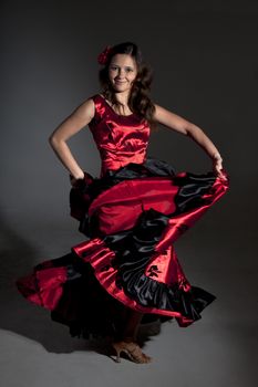 Young woman dancing flamenco, studio shot, gray background