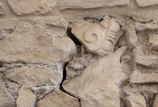 Ancient wall with an older fragment of a column in it