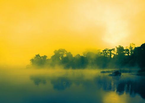 Sunrise in the Mist on lake and reflection on the water.