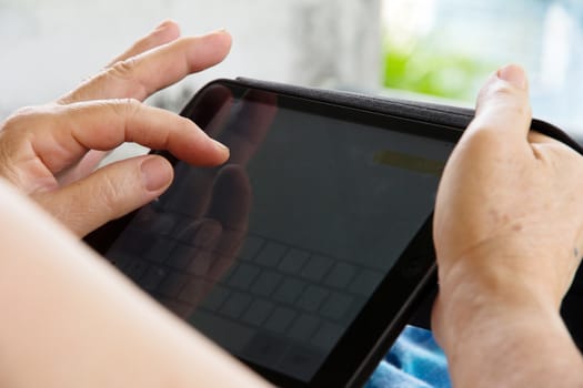 Senior woman using tablet at home