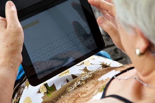 Senior woman using tablet at home