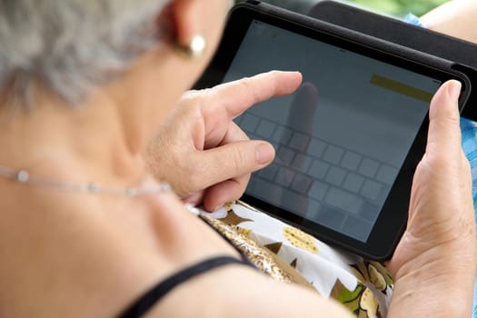 Senior woman using tablet at home