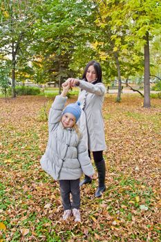 Photo of smiling mother and daughter play in autumn