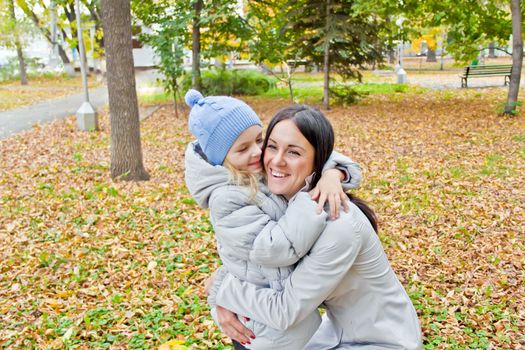 Photo of smiling mother and daughter in autumn