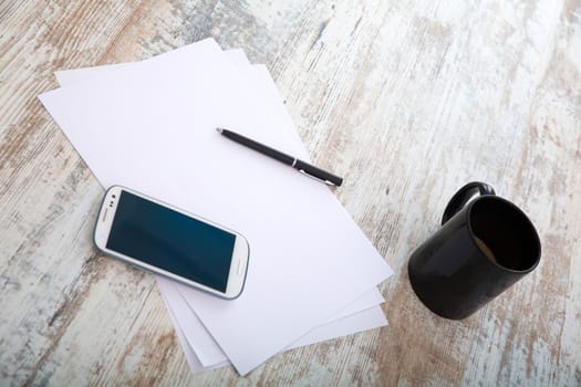 Taking notes at the table with coffee and smartphones.